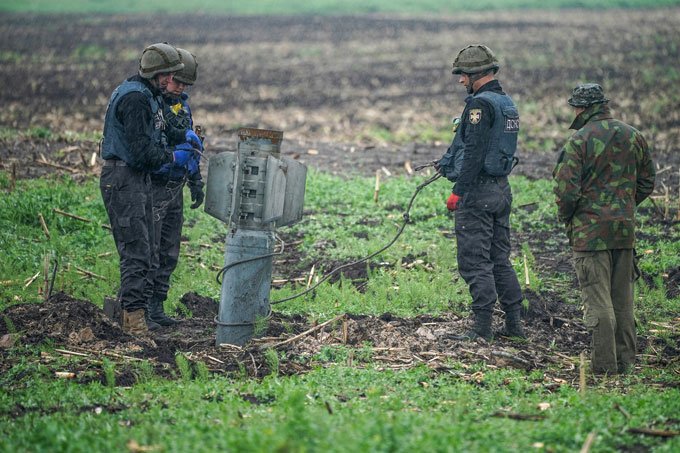 people removing a rocket from a field