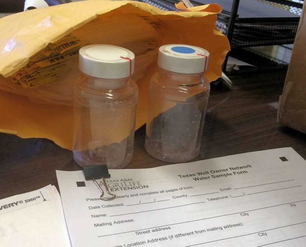 two water collection bottles for testing with a form that needs to be filled out.