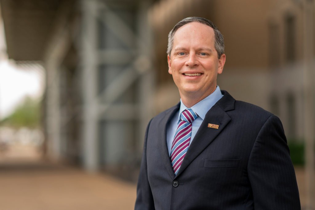 A man in a suit and tie standing outside, Stephen Cisneros Headshot