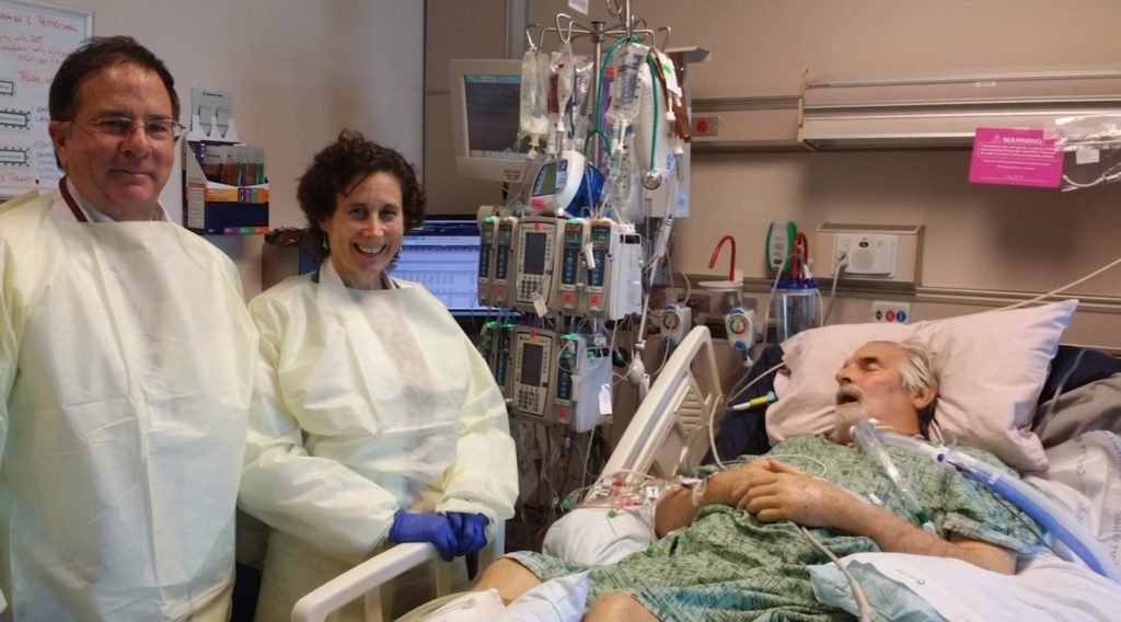 Patterson in hospital bed. Dr. Schooley standing at left 