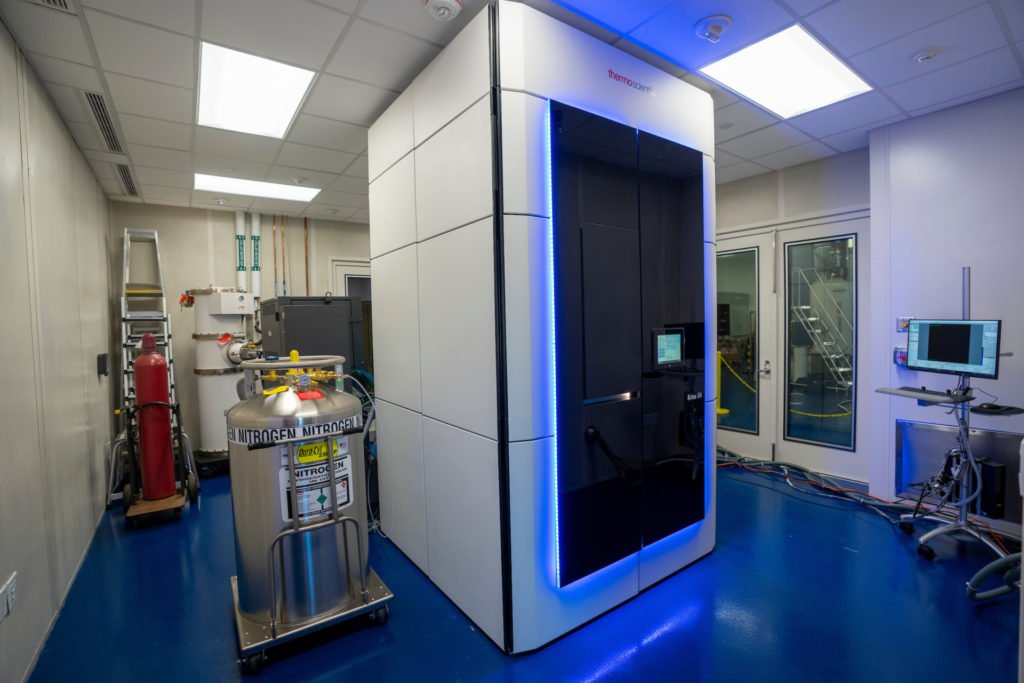 Sleek white container, computers and other equipment in an enclosed lab space.