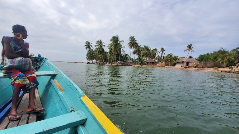 A passenger en route to Hauvi by motor boat via the Volta River. Image by Erica Ayisi for Mongabay.