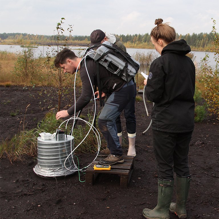 Snowchange ecologist Antoine Scherer, left, measures methane and carbon dioxide fluxes with a state-of-the-art trace gas analyzer in Linnunsuo, 2021, with staff member Noora Huusari, right, recording the flux readings. Exact greenhouse gas measurements on rewilded sites are needed in order to monitor and demonstrate the success and speed of recovery of the rewilding projects. 