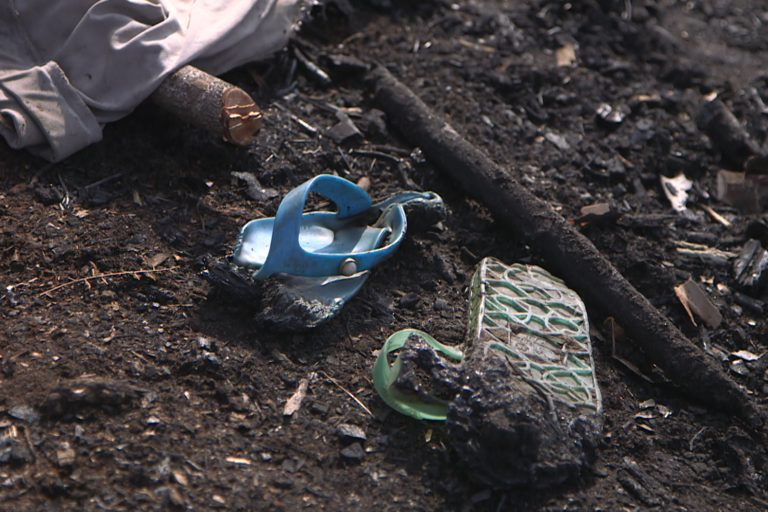 The shoes of a Mutwa community member warped by flames, lying among the ashes in a village entirely burnt to the ground in park guards and soldiers in July 2021.