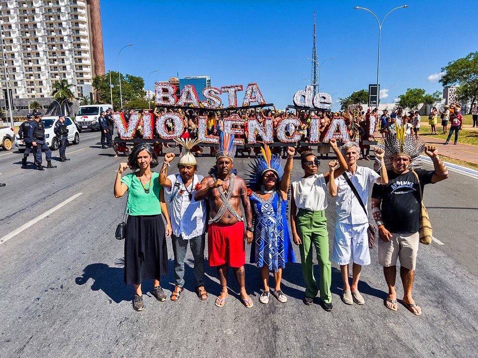 Protesters hold a sign saying “Enough violence.” 