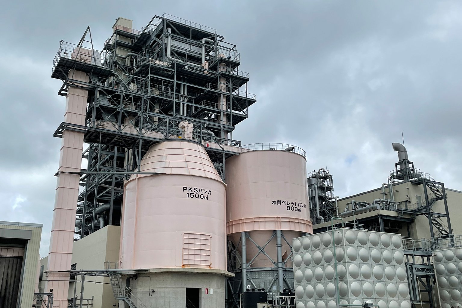 Tanks storing palm kernel shells (PKS) and wood pellets at a biomass power plant in Okinawa Prefecture, Japan. Photo by Annelise Giseburt.