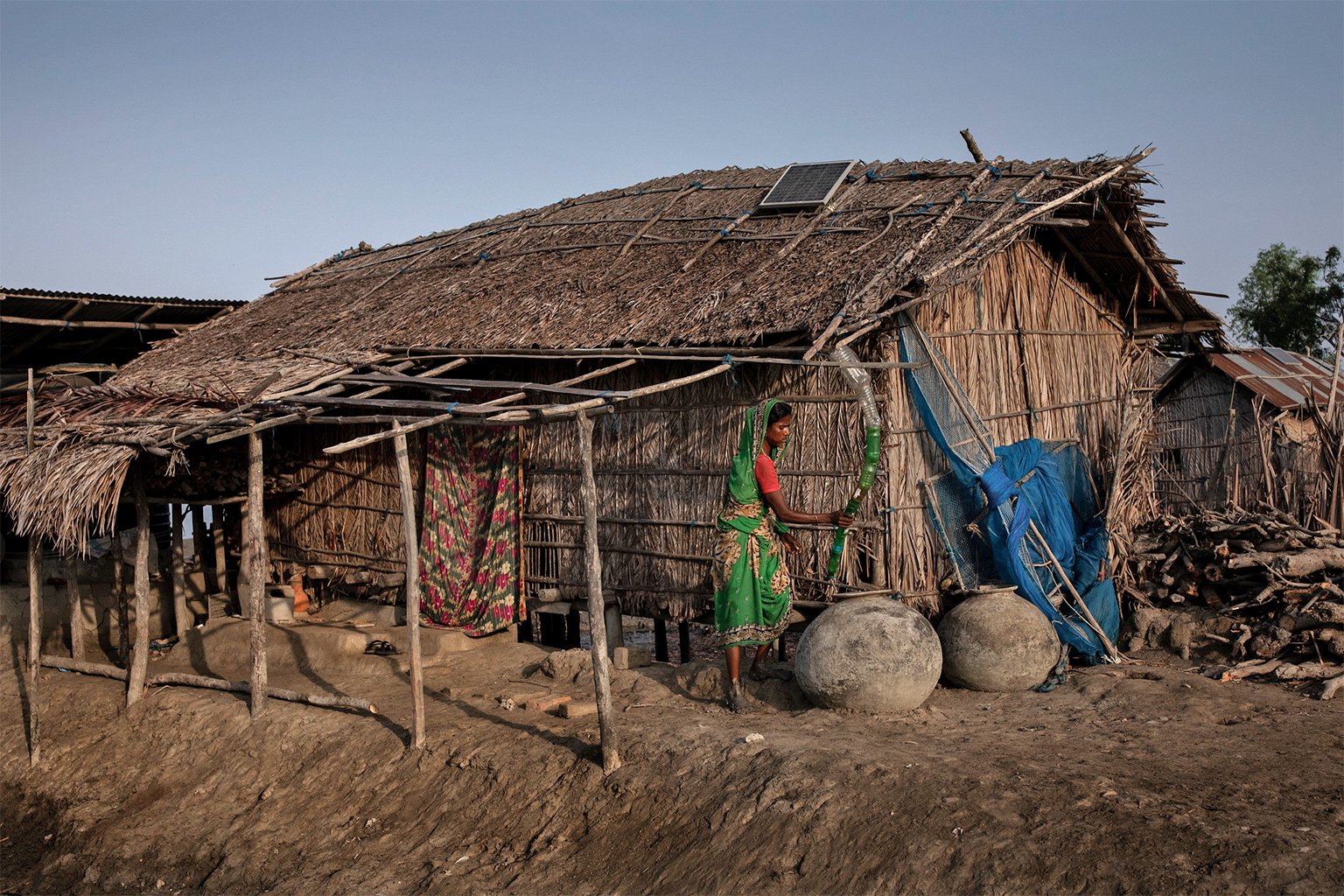 A woman living in the Sundarbans region collects rainwater in plastic bottles during the dry season.