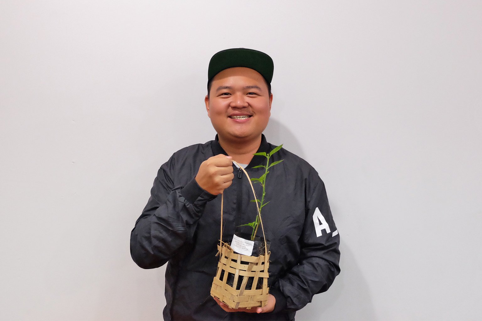 Yohanes Sugihtonugroho holds a sapling. 