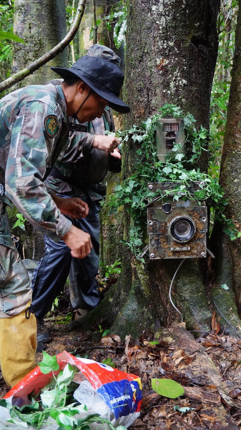 Photo assistant Lek wrapping Bruce's cameras in rattan vine. Image courtesy of Greg McCann.
