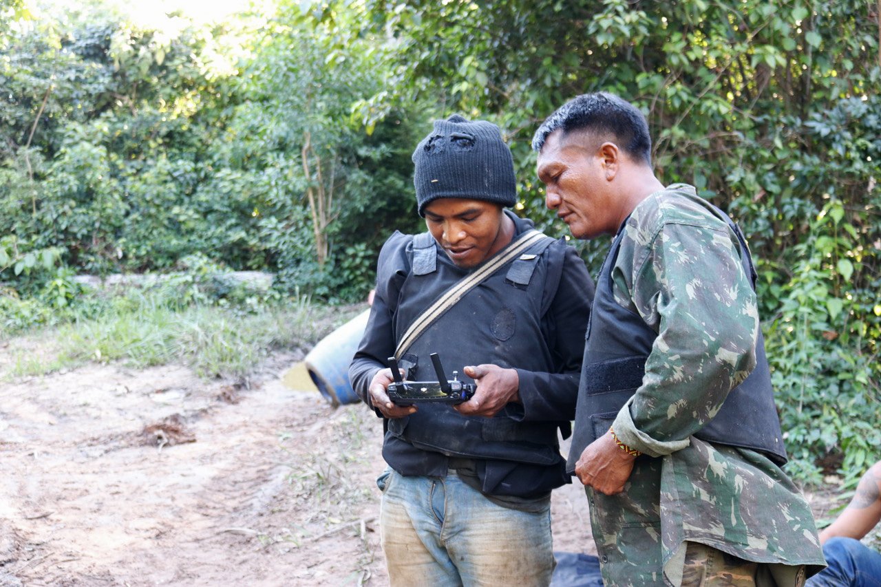 Indigenous leader Paulo Paulino Guajajara, left, and Indigenous chief Olímpio Iwyramu Guajajara, right, both “Guardians of the Forest,” monitor a drone in the Arariboia Indigenous Territory in Brazil’s Maranhão state. Image courtesy of Sarah Shenker/Survival International.