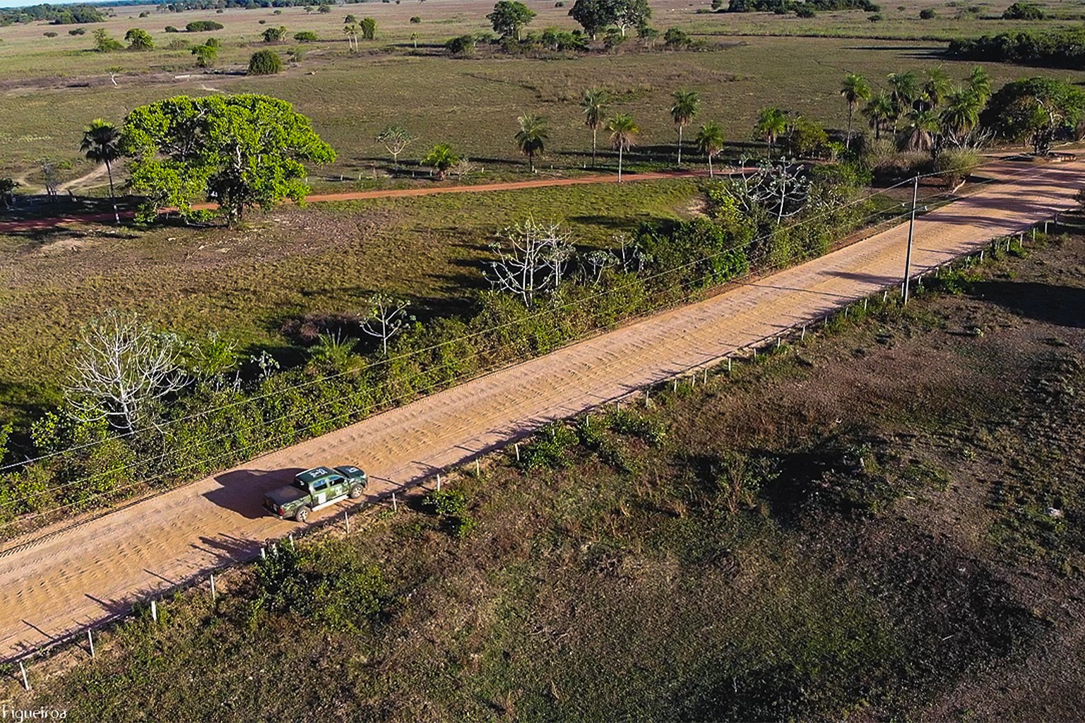 A dust track cuts across the landscape in Mato Grosso state. 