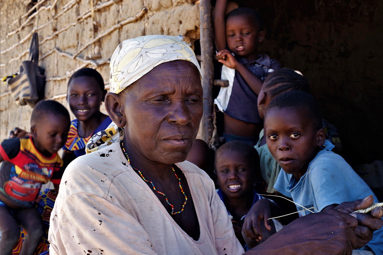 Ngombo Tsuma’s wife plaits a rope outside their home.