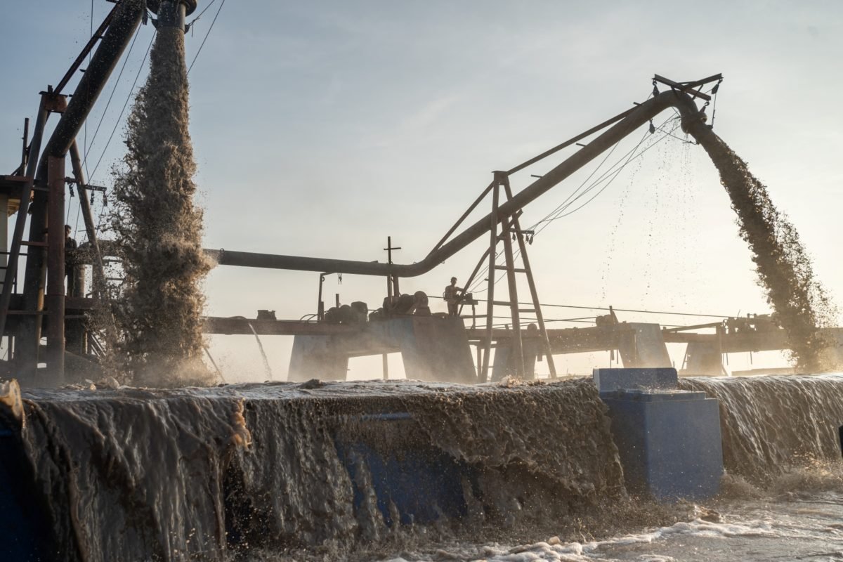 Sand mining barges extract sand from the Mekong
