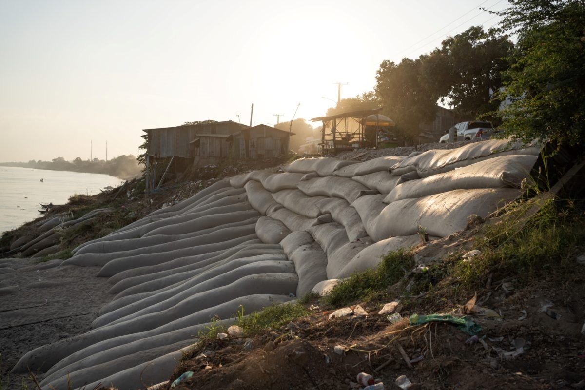 Bags filled with sand are placed at a riverbank collapse to temporarily prevent any further erosion.
