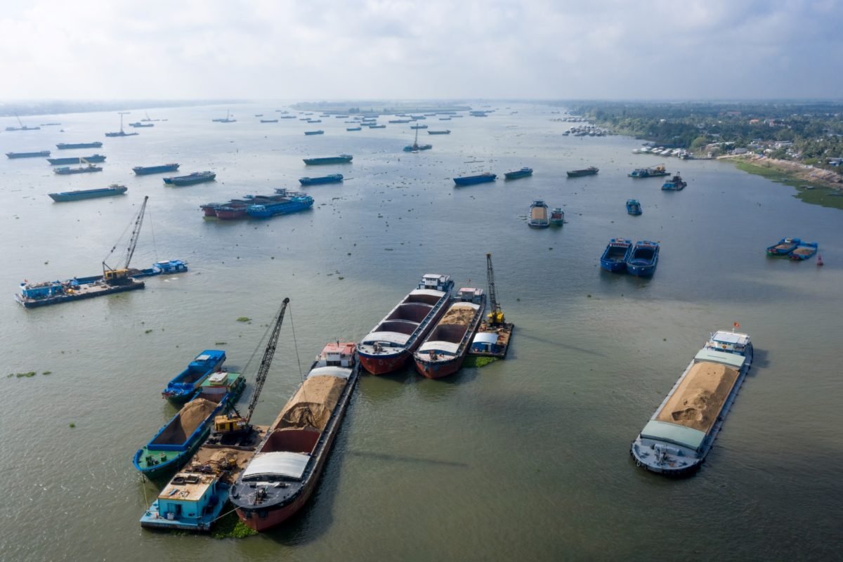 Sand mining barges mine sand on the Vietnam-Cambodia border of the Mekong River.