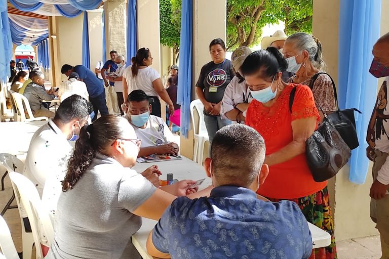 Asunción Mita residents wait their turns to vote in a local referendum on mining at outdoor tables in front of the municipal government building, on one side of the town plaza.